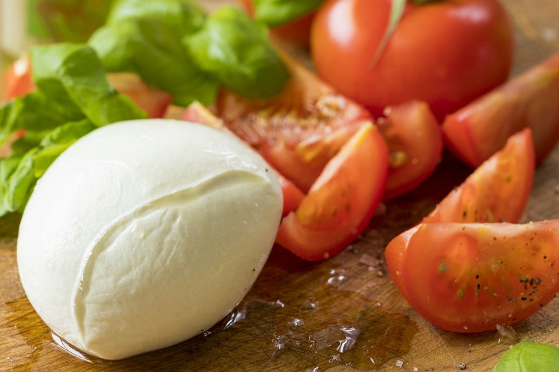 Bol mozarella met gesneden tomaten en basicilum